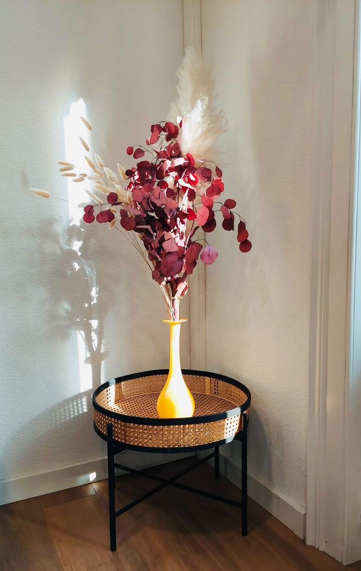 Blumenvase auf einem Beistelltisch im Sonnenlicht